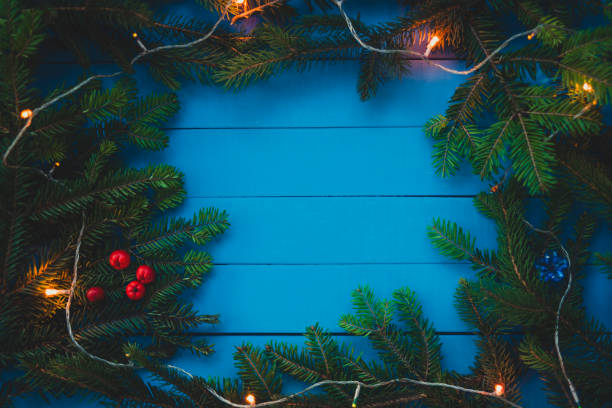 istock Evergreen branch with Christmas light on blue boards 885351668