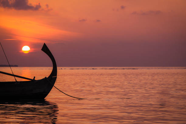 traditional Maldivian Dhoni Boat on Water at Sunset