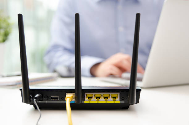 istock Wireless router and man using a laptop in office 885365260