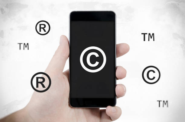 istock Copyright, trademark symbols flying around smartphone. 885367634