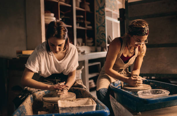 istock Two women at a pottery workshop making clay pots 885390996