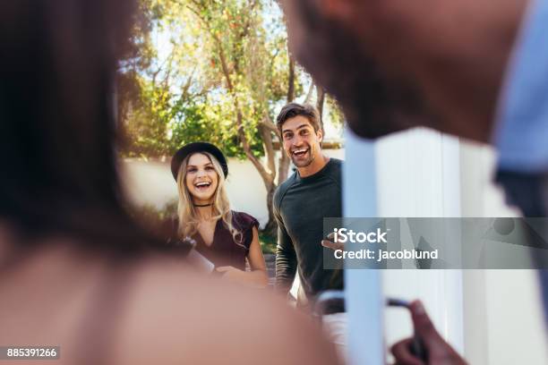 Couple Attending Friends Housewarming Party Stock Photo - Download Image Now - Arrival, Guest, Greeting