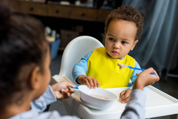 istock african american sister feeding brother 885394444