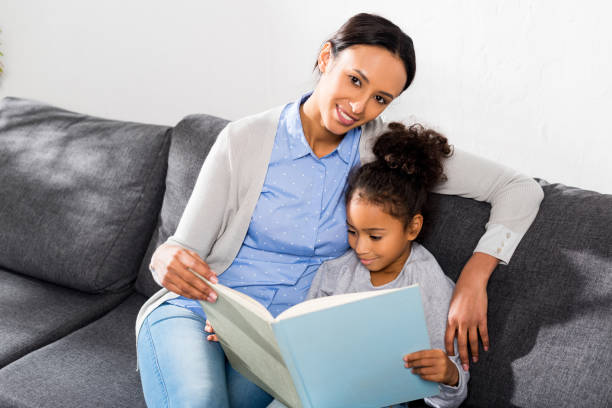 istock mother and daughter reading book 885400606
