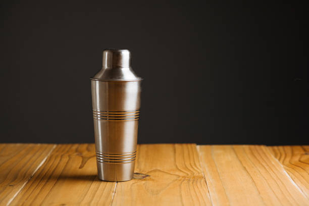 istock Cocktail shaker on wooden table on dark background 885408530