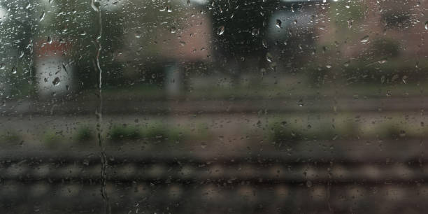 istock Drops of rain at a window with blurred rails 885408580