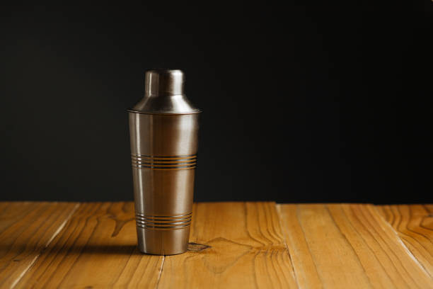 istock Cocktail shaker on wooden table on dark background 885408582