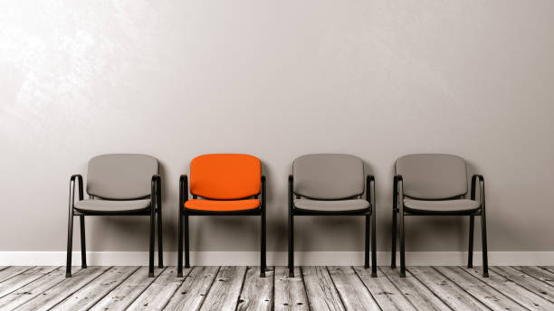 istock One Different Colored Chair in a Row of Grey 885411526