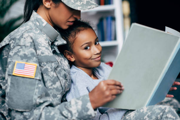 istock daughter and female soldier reading book 885412360