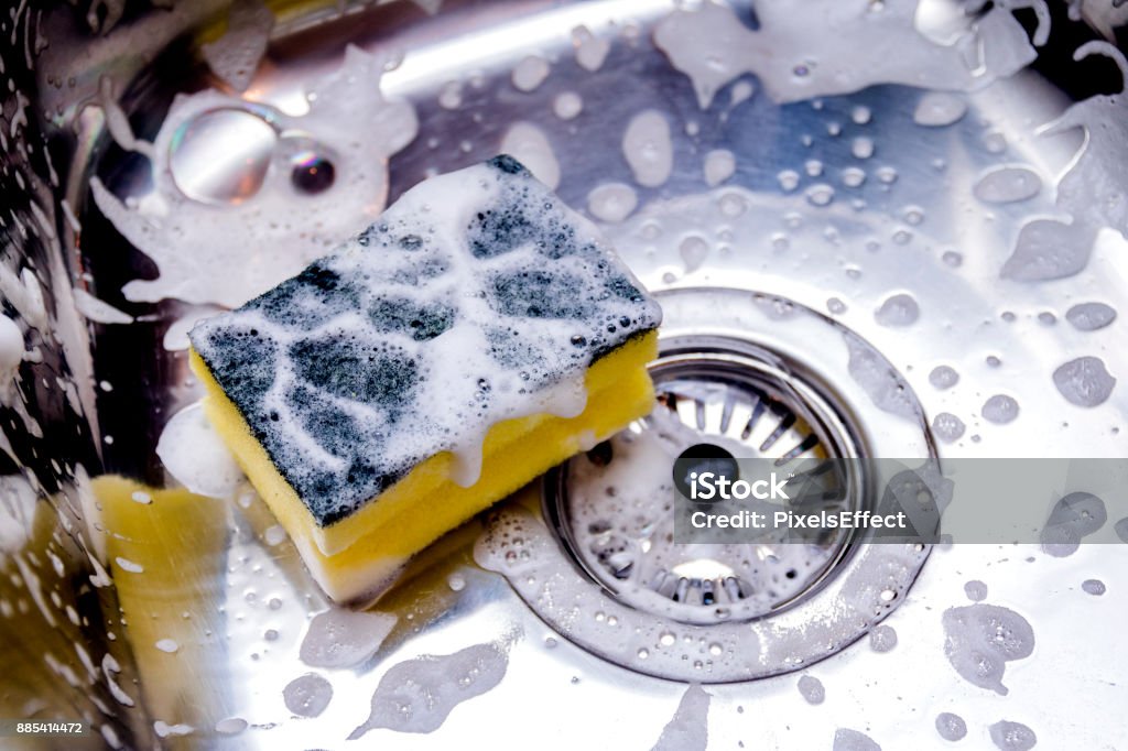 cleaning the sink in kitchen sponge in kitchen sink. Home cleaning concept. Kitchen Stock Photo