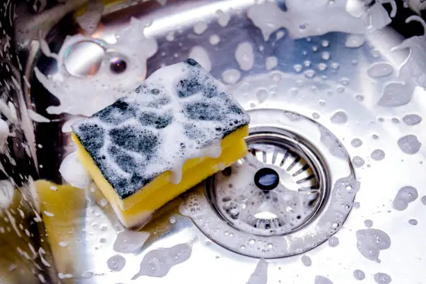 sponge in kitchen sink. Home cleaning concept.