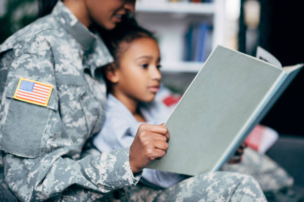 istock daughter and mother in military uniform with book 885414772