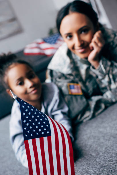 istock daughter and mother with american flag 885415106