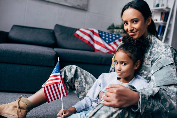 istock daughter and mother with american flag 885415182