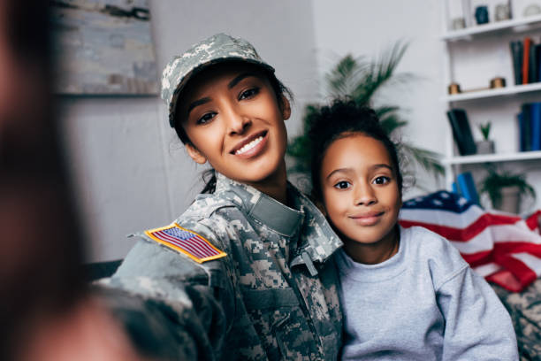 istock daughter and soldier taking selfie 885415518