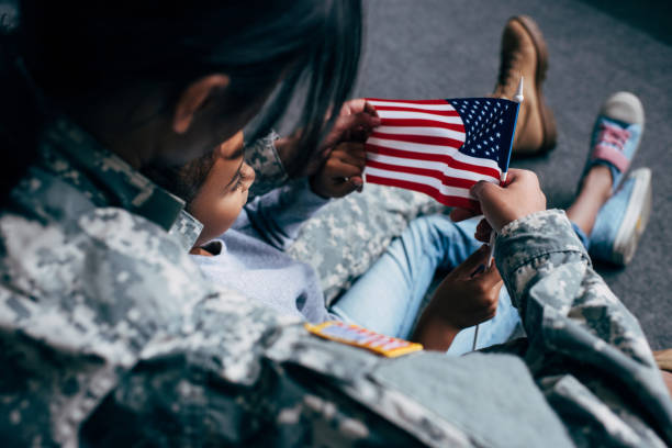 istock daughter and soldier with american flag 885416774