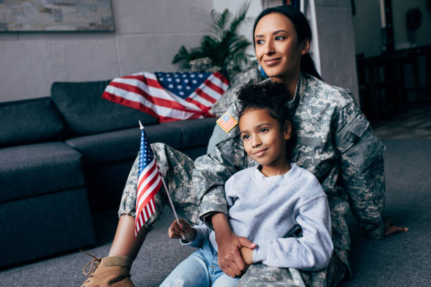 istock daughter and soldier with american flag 885418020