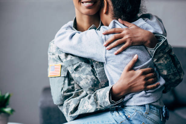 istock daughter hugging mother in military uniform 885420854