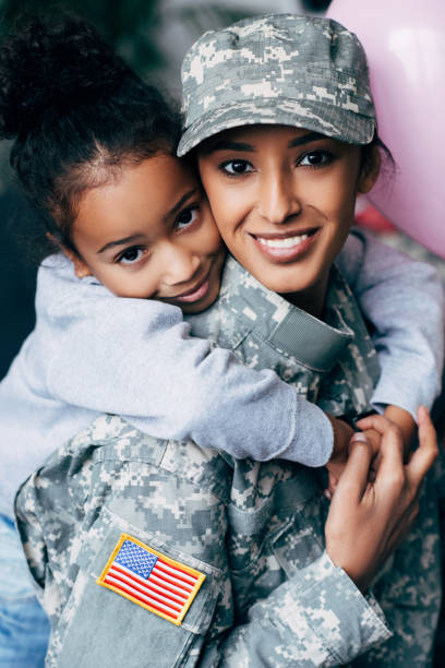 istock daughter hugging mother in military uniform 885420902