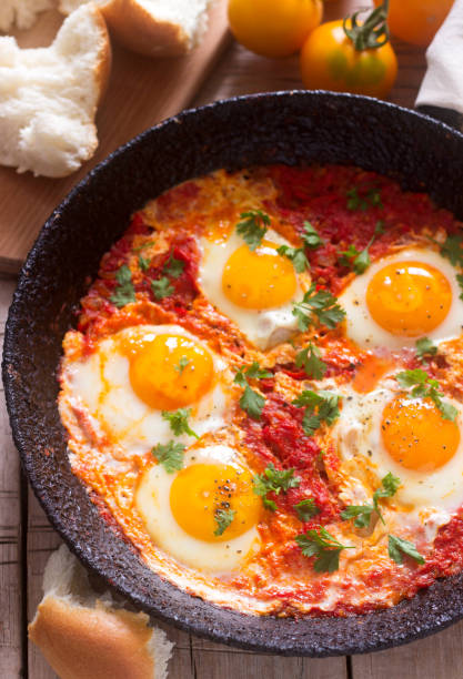 istock Shakshuka with bread on a wooden table. Middle eastern traditional dish. Homemade. Selective focus. 885425914