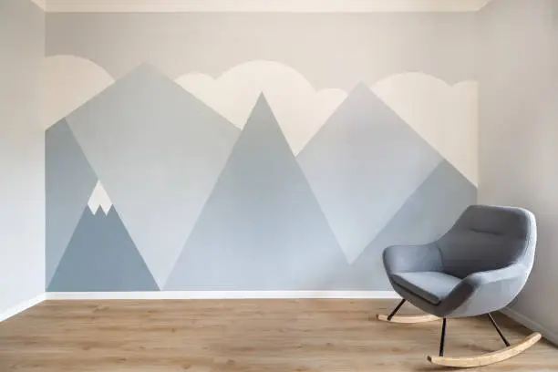 Modern, sleek style room with light oak wooden floor, white skirting and minimalist style mural of mountains. Copy space on the left.