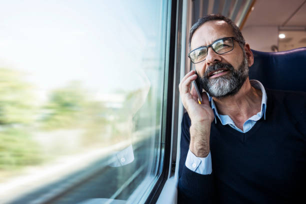 Mature businessman in train Mature businessman in train passenger train stock pictures, royalty-free photos & images