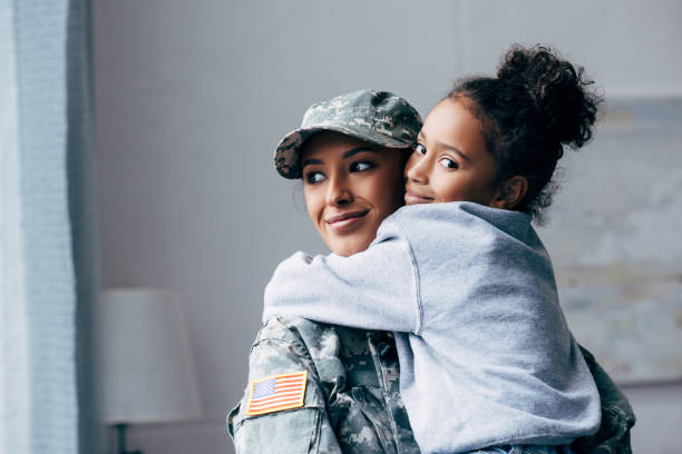 soldier holding daughter on arms smiling african american soldier in military uniform holding daughter on arms at home 2012 stock pictures, royalty-free photos & images