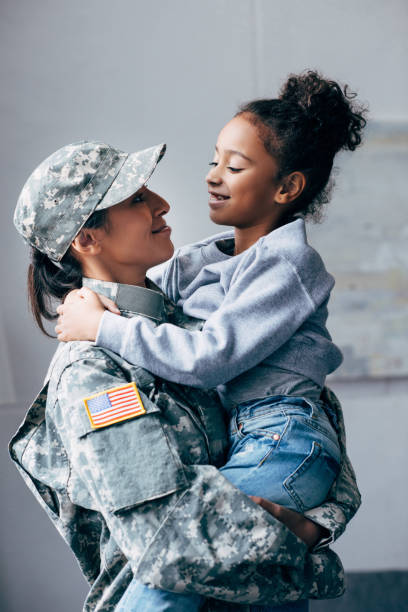 soldier holding daughter on arms african american woman in military uniform holding daughter on arms at home the black womens expo stock pictures, royalty-free photos & images