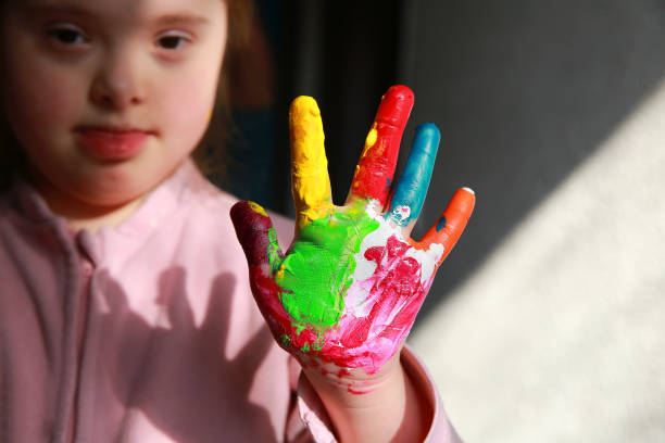 istock Down syndrome girl with painted hands 885448752