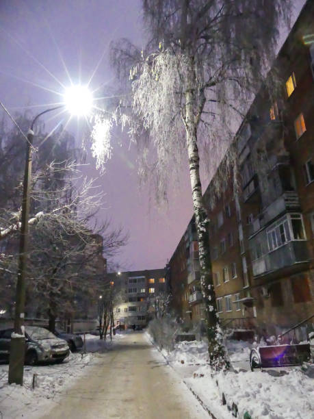istock Empty city alley winter snow building lantern evening 885452430