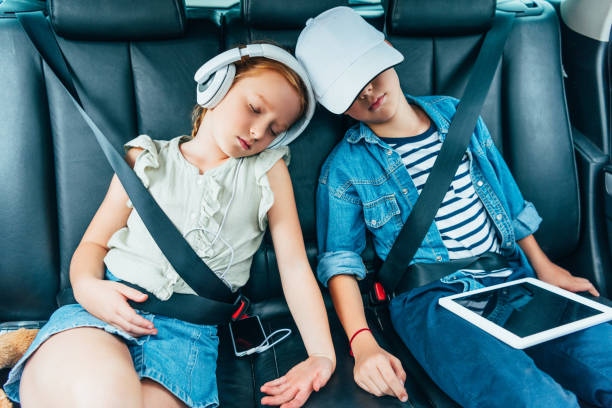 kids sleeping on backseats of car brother and sister sleeping on backseats of car while having trip back seat photos stock pictures, royalty-free photos & images