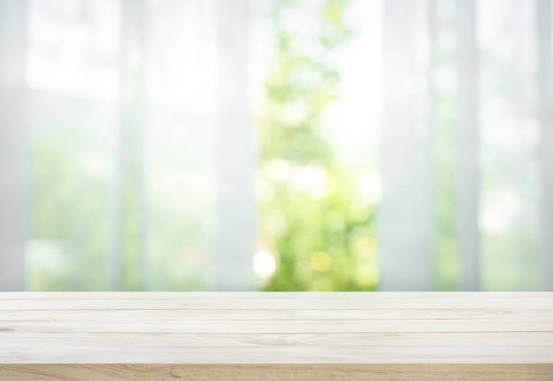 holztisch auf unschärfe des vorhangs mit fenster blick garten - vorhang fotos stock-fotos und bilder