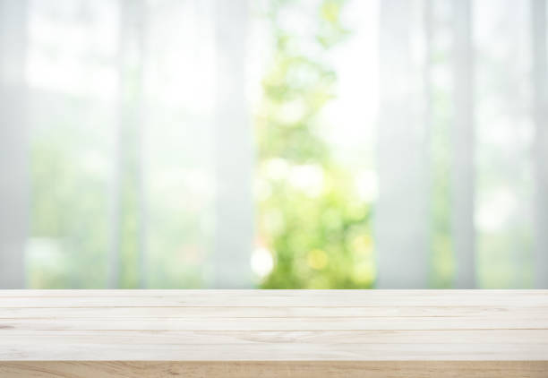 ウィンドウ ビュー ガーデン カーテンのぼかしの木製テーブル - カーテン ストックフォトと画像