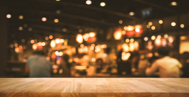 istock Wood table with blur light bokeh in dark night cafe 885452994