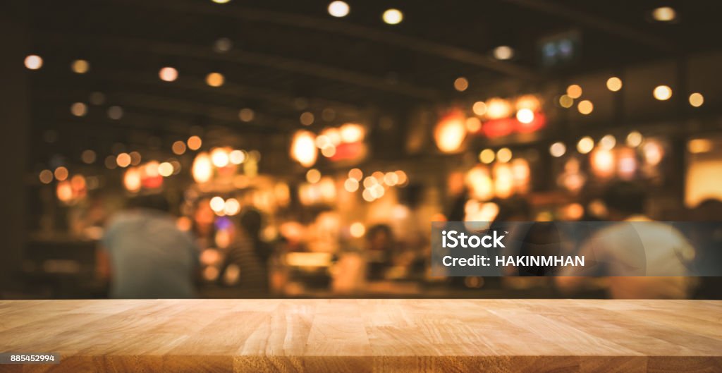 Wood table with blur light bokeh in dark night cafe Wood table top (Bar) with blur light bokeh in dark night cafe,restaurant background .Lifestyle and celebration concepts ideas Pub Stock Photo