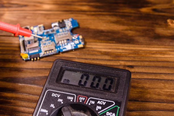 istock Inspecting of the electronic circuit board with multimeter 885468804