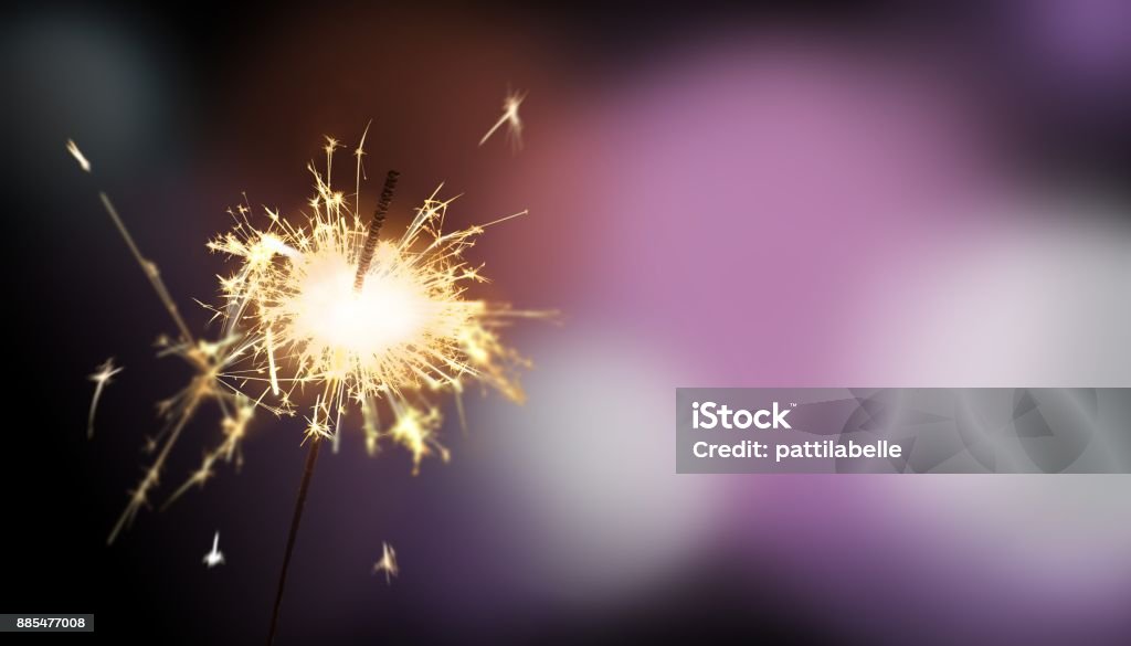 sparkler - New Year / New Year's Eve / celebration sparkler in front of purple colored blurred background for New Year's Eve / celebration Sparkler - Firework Stock Photo