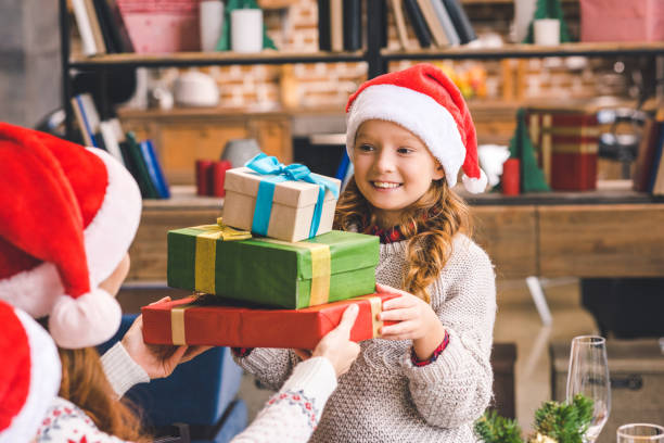 istock girl giving stack of presents to mother 885484026