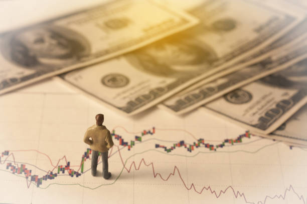istock Miniature business man on stock market graph or 885491734