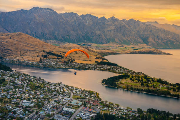 Paragliding over Queenstown and Lake Wakaitipu, New Zealand Cityscape of Queenstown and Lake Wakaitipu with The Remarkables and mountain around from viewpoint at Queenstown Skyline, South Island of New Zealand airborne sport stock pictures, royalty-free photos & images