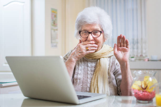 istock Shocked senior woman using laptop at home. 885522700