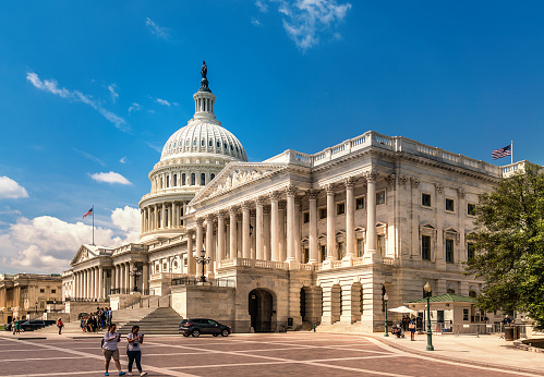 Washington DC - June 6, 2017: United States Capitol Building in Washington DC - East Facade of the famous US landmark with tourists walking around and taking pictures.