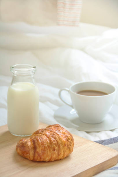 istock Bed breakfast with coffee cup, croissants and milk in bed 885537476