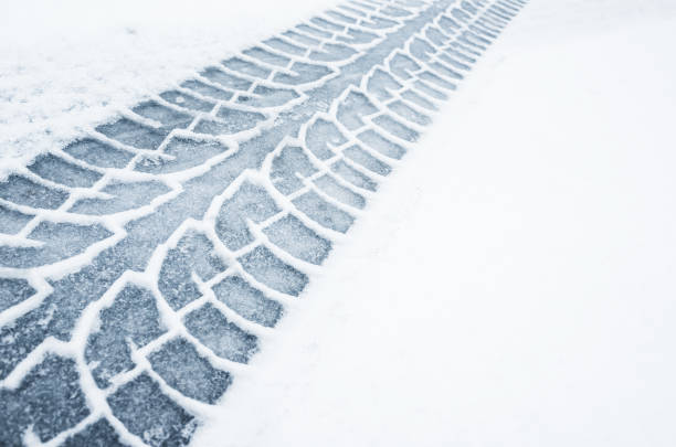 car track on a wet snowy road, closeup - winter driving imagens e fotografias de stock