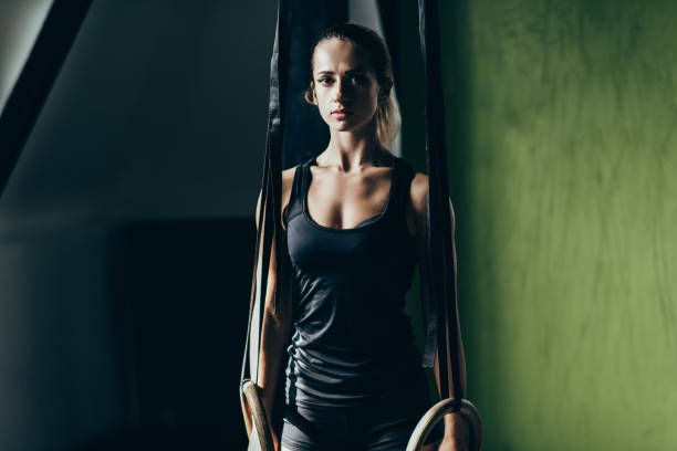 istock athletic sportswoman with gymnastic rings 885542138