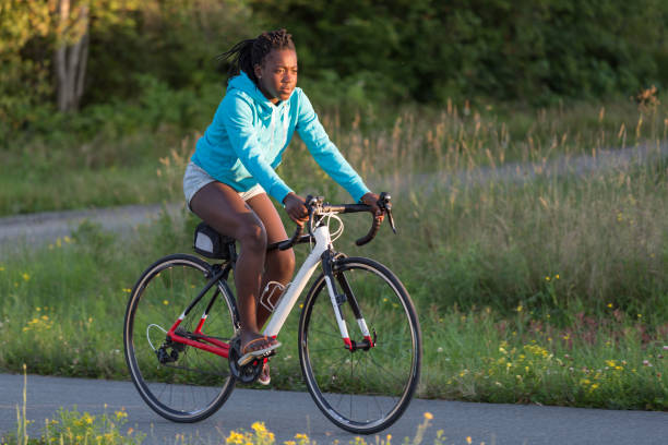 cyclist rides her bike at sunset - ten speed bicycle imagens e fotografias de stock