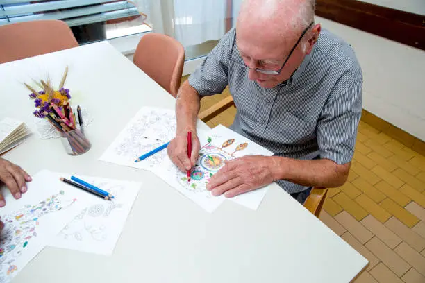 Senior Man Coloring An Adult Coloring Book