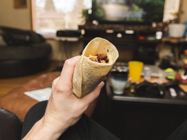 istock Holding Breakfast Burrito in Living Room 885575086