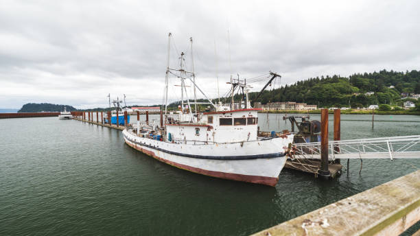 White and red fishing or crabbing boat in a slip at a marina.