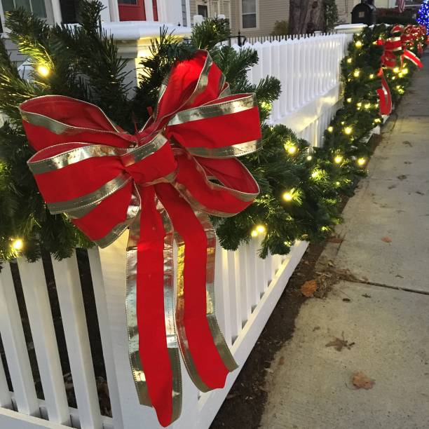 istock A welcoming Christmas bow on a white picket fence 885591400
